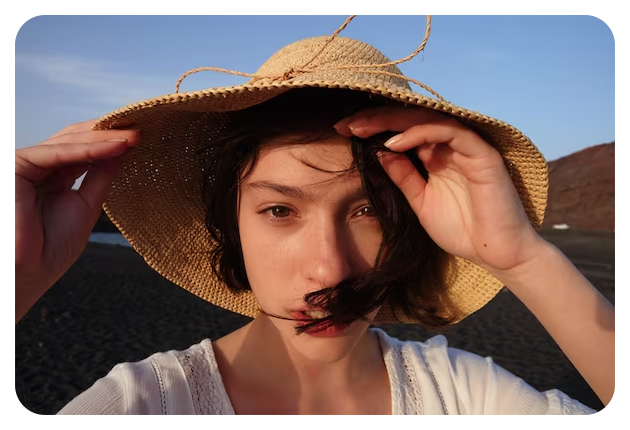Sony RX0 II sample image close up portrait of woman with short brown hair wearing woven flat brimmed hat with her hands pushing hair back